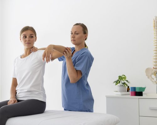 physiotherapist-helping-young-female-patient-her-clinic